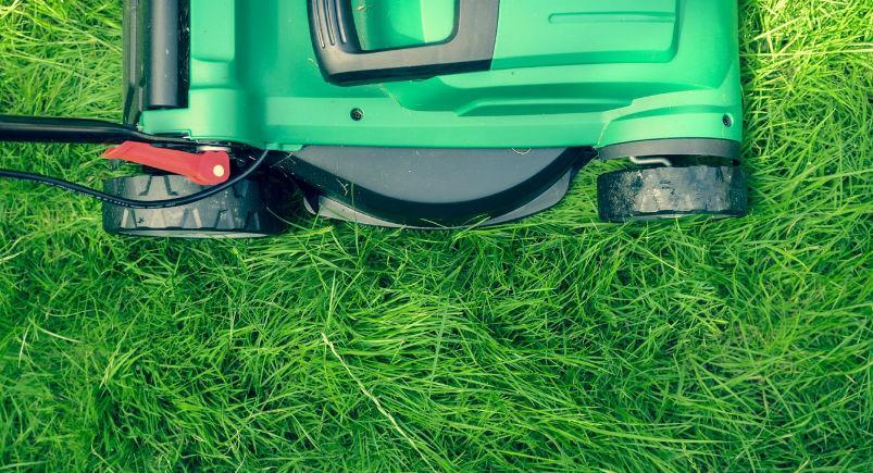 A landscaper mowing a yard